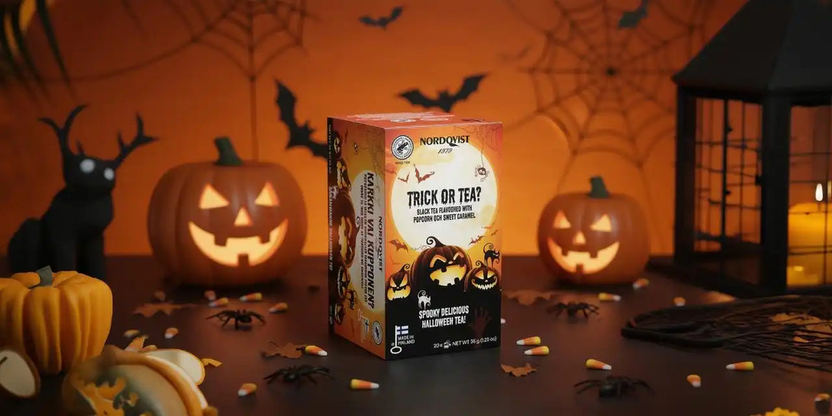 Halloween-themed tea box with a spooky design featuring black and orange colors, spiderweb pattern, and ’trick or teat’ text.