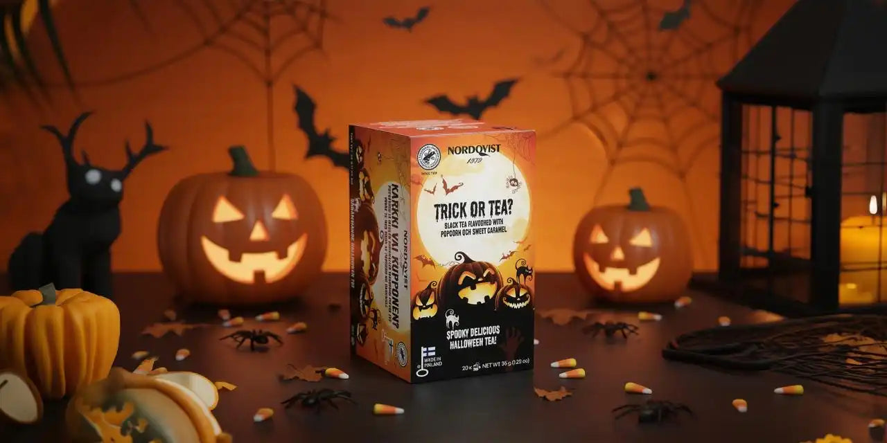 Halloween-themed tea box with a spooky design featuring black and orange colors, spiderweb pattern, and ’trick or teat’ text.