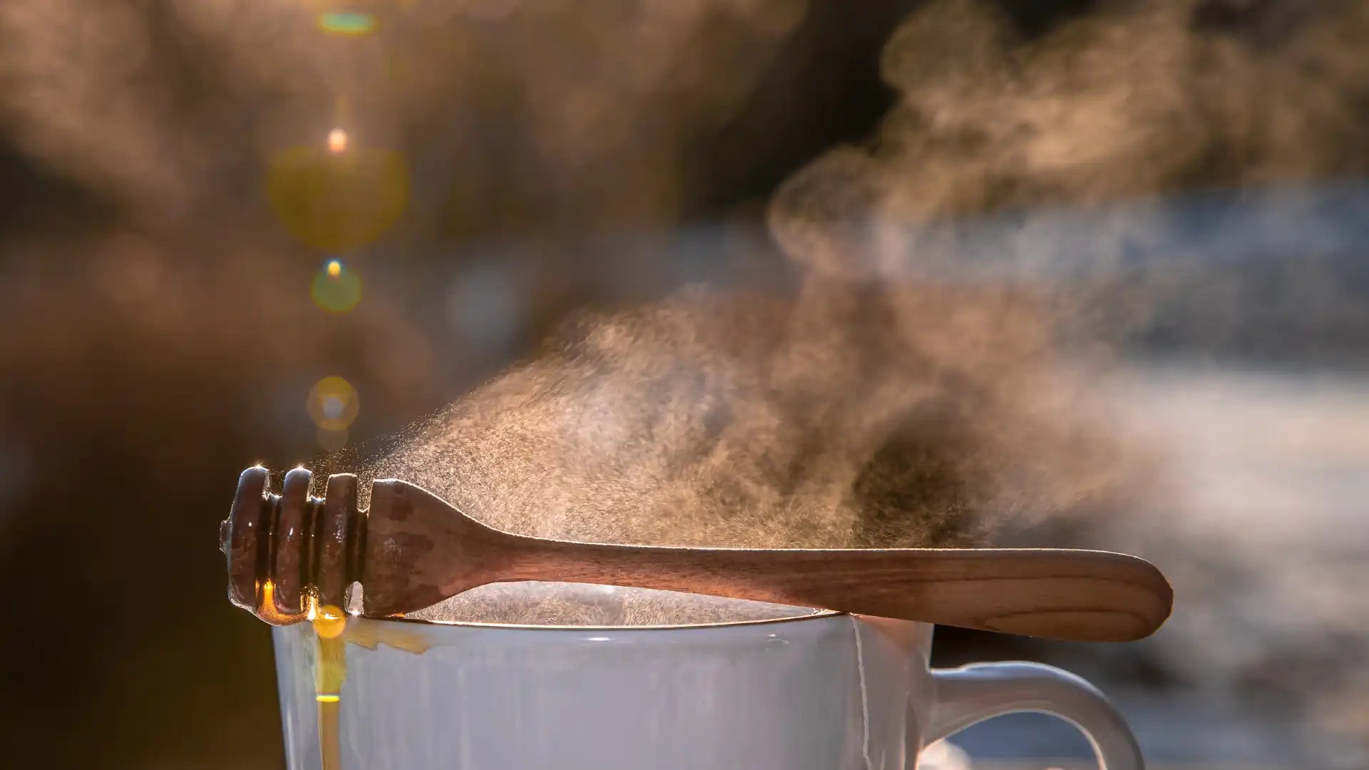 Wooden honey dipper with a curved handle and metal bowl, featuring natural wood grain texture.